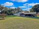 Single-story home features a carport, lush lawn, and plenty of backyard space at 13521 N Magnolia Ave, Citra, FL 32113