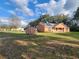 Charming single-story home with solar panels, a covered porch, and a well-maintained lawn with outbuildings at 13521 N Magnolia Ave, Citra, FL 32113