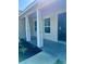 Covered entryway featuring white columns, dark door, and concrete porch at 13936 Sw 113 Ln, Dunnellon, FL 34432