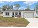 Charming single-story home featuring a well-manicured lawn and a bright white exterior at 14404 Sw 19Th Pl, Ocala, FL 34481