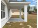 Covered back patio featuring painted columns and a peaceful view of the expansive yard at 14404 Sw 19Th Pl, Ocala, FL 34481