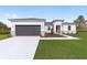 Modern home featuring a gray garage door, bright white exterior, and a well-manicured green lawn at 16171 Sw 48Th Cir, Ocala, FL 34473