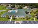 Aerial view of the clubhouse, pool, tennis courts, and surrounding landscaping in the community at 1921 Nw 50Th Cir, Ocala, FL 34482