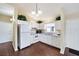 Well-lit kitchen boasts white appliances and cabinetry, as well as sleek hardwood flooring at 1921 Nw 50Th Cir, Ocala, FL 34482