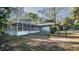 View of a backyard with a screened-in enclosure, surrounded by a chain-link fence at 20260 Sw 95Th St, Dunnellon, FL 34431