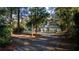 A long driveway leading up to a home surrounded by mature trees at 20260 Sw 95Th St, Dunnellon, FL 34431