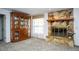 Elegant living room with stone fireplace, plush carpet, and wooden china cabinet at 20260 Sw 95Th St, Dunnellon, FL 34431