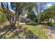 Spacious backyard features a patio with outdoor seating amidst mature landscaping at 2310 Nw 59Th Ave, Ocala, FL 34482