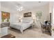 Bright bedroom with neutral colors, large window, ceiling fan, and a decorative writing desk at 2310 Nw 59Th Ave, Ocala, FL 34482