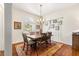 Bright dining room featuring wood table and chairs under an elegant chandelier, complemented by a colorful area rug at 2310 Nw 59Th Ave, Ocala, FL 34482