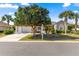 Charming home featuring a two-car garage, mature landscaping, and a well-manicured front lawn at 2310 Nw 59Th Ave, Ocala, FL 34482