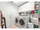 Functional laundry room with washer, dryer, storage cabinets, and utility sink at 2310 Nw 59Th Ave, Ocala, FL 34482