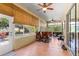 Bright sunroom featuring tiled floor, ceiling fans, bamboo shades, and sliding glass door to the outdoor patio at 2310 Nw 59Th Ave, Ocala, FL 34482