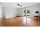 Bright living room featuring wood floors, ceiling fan, and access to the backyard through French doors at 23761 Sw Plaza Ct, Dunnellon, FL 34431