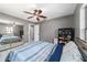 Gray bedroom features tile flooring, a ceiling fan, and a closet with a mirrored door at 2620 Sw 152Nd Ln, Ocala, FL 34473