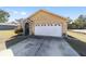 Home featuring a two-car garage and stone accents around front door and manicured shrubs at 2620 Sw 152Nd Ln, Ocala, FL 34473