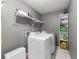 Bright laundry room equipped with a washer, dryer, shelving and modern gray paint at 2620 Sw 152Nd Ln, Ocala, FL 34473