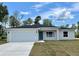 Charming single-story home featuring a two-car garage, a teal front door, and a well-manicured lawn at 269 Marion Oaks Golf Way, Ocala, FL 34473