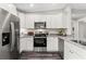 Well-lit modern kitchen with white cabinetry, stainless steel appliances, and granite countertops at 269 Marion Oaks Golf Way, Ocala, FL 34473