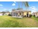 Spacious backyard view featuring a screened patio with an outdoor dining set and mature landscaping at 3001 Rugby Way, The Villages, FL 32162