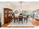 Dining room boasts a wooden table, chairs, and cabinet, with natural light streaming through sliding glass doors at 3001 Rugby Way, The Villages, FL 32162