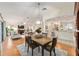 Open-concept dining area with a wooden table and chairs adjacent to the living room and kitchen at 3001 Rugby Way, The Villages, FL 32162