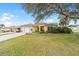 Charming single Gathering home with a two-car garage, a well-manicured lawn and a large tree at 3001 Rugby Way, The Villages, FL 32162