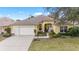 Charming yellow single Gathering home with a two-car garage, beautiful walkway and a well-manicured lawn at 3001 Rugby Way, The Villages, FL 32162