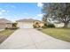 Charming yellow single Gathering home with a two-car garage, a well-manicured lawn and blue sky at 3001 Rugby Way, The Villages, FL 32162