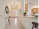 Bright hallway with a tiled floor leading to the entryway and kitchen area at 3001 Rugby Way, The Villages, FL 32162