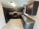 Well-lit kitchen with dark cabinets, modern appliances, and tiled floors at 3044 Sw 168Th Loop, Ocala, FL 34473