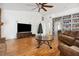 Living room features wood floors, a ceiling fan, built in shelving, and a Christmas tree at 3994 Sw 102Nd Pl, Ocala, FL 34476