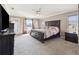 Main bedroom with ensuite, ceiling fan, and carpet floors at 3994 Sw 102Nd Pl, Ocala, FL 34476