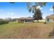 Large backyard features a sunroom attached to the house and mature trees providing ample shade at 4837 Ne 5Th Street Rd, Ocala, FL 34470