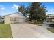 View of the detached garage, accessible via a long driveway, near a cozy sunroom attached to the house at 4837 Ne 5Th Street Rd, Ocala, FL 34470