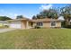 Charming single-story home featuring a well-manicured lawn and a beige color scheme with a two car garage at 4837 Ne 5Th Street Rd, Ocala, FL 34470