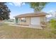 A detached garage features a white door and a green side entry door, with ample parking space at 4837 Ne 5Th Street Rd, Ocala, FL 34470