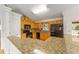 Well-lit kitchen featuring wood cabinetry, granite counters, and modern black appliances at 4837 Ne 5Th Street Rd, Ocala, FL 34470