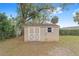 Outdoor storage shed with white trim and a light-colored exterior provides additional storage space at 4837 Ne 5Th Street Rd, Ocala, FL 34470