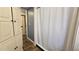 Bathroom with storage cabinet and shower featuring a white shower curtain at 615 Ne Cottage Park Ln, Leesburg, FL 34748