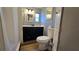 Bathroom with vanity, mirror, updated lighting, toilet, and shower with curtain at 615 Ne Cottage Park Ln, Leesburg, FL 34748