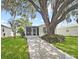 Charming single-story home featuring a concrete driveway and well-maintained lawn at 615 Ne Cottage Park Ln, Leesburg, FL 34748