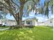 Charming single-story home featuring a well-maintained lawn and beautiful mature trees offering plenty of shade at 615 Ne Cottage Park Ln, Leesburg, FL 34748
