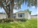 Charming single-story home featuring a well-maintained lawn and beautiful landscaping at 615 Ne Cottage Park Ln, Leesburg, FL 34748