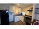 The kitchen features white cabinets and essential appliances at 615 Ne Cottage Park Ln, Leesburg, FL 34748