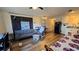 Cozy living room that leads to the kitchen with wood-look floors at 615 Ne Cottage Park Ln, Leesburg, FL 34748