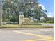 Pennbrooke Fairways sign at the front entrance with landscaping and American flags at 615 Ne Cottage Park Ln, Leesburg, FL 34748