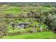 Aerial view of a large home with a sprawling lawn, mature trees, and surrounding green fields at 6994 Nw 320 Hwy, Micanopy, FL 32667