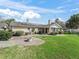 Backyard view of a well-maintained lawn with a patio and a home with solar panels at 6994 Nw 320 Hwy, Micanopy, FL 32667