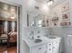 Bright bathroom showcasing a dual sink vanity with unique tile work and access to the main bedroom at 6994 Nw 320 Hwy, Micanopy, FL 32667